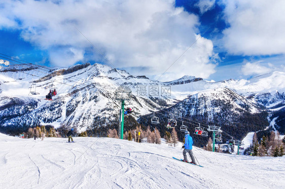 无法辨认的滑雪者和单板滑雪者乘坐缆车上去加拿大落基山脉图片