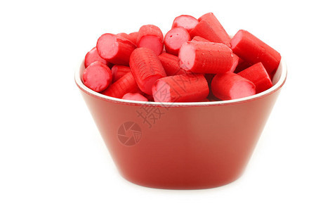 白色背景上的红色碗里装满粉红色的红色糖果背景图片
