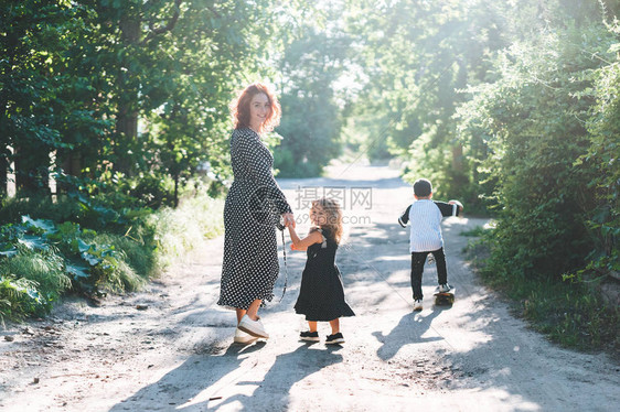 一个女人和她的孩子在路上散步阳图片