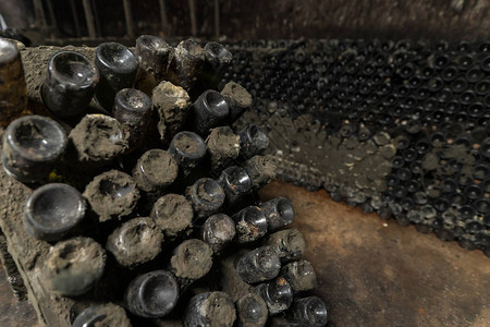 葡萄酒架旧瓶装满灰尘和天然图片