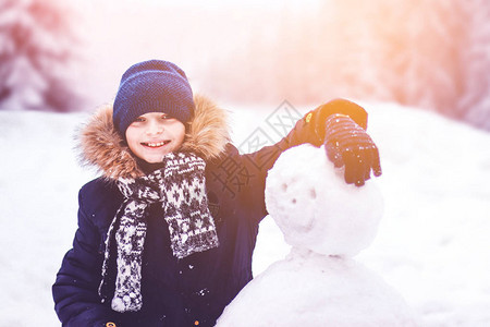 一个孩子雕塑了一个雪人一个男孩在冬图片