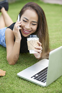 快乐的亚洲年轻女子喝着外送咖图片