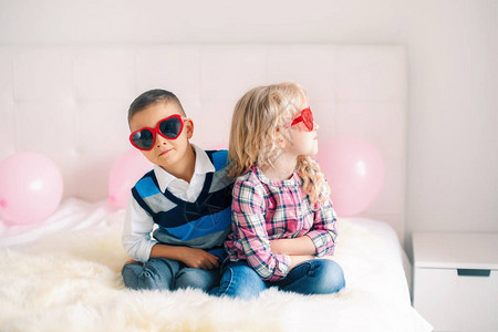 两个不开心的白人可爱有趣的孩子戴着心形眼镜的肖像图片
