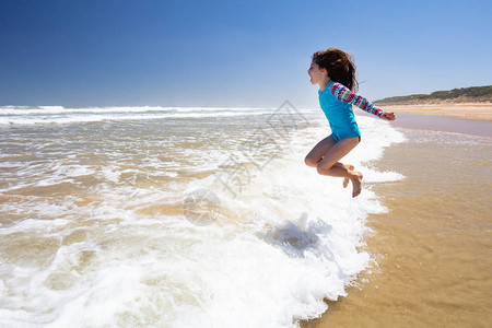 在澳洲维多利亚贝拉林半岛第十三海滩的海浪中玩耍的欢乐儿图片