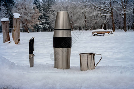 冬季户外的热水瓶和杯子远足图片