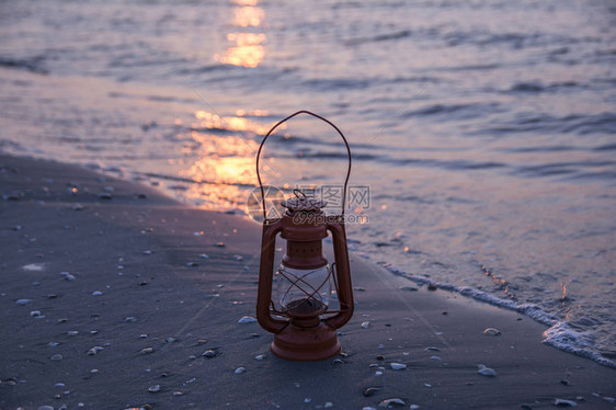日出时海上的老式油灯图片