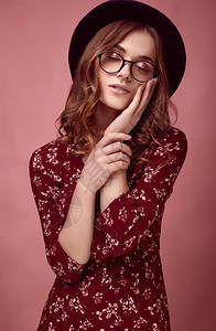 穿着红色时装黑帽子和眼镜的优雅光华丽时装女郎感人肖像图片