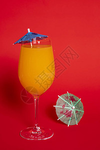 杯子上装着蓝色雨伞的橙色饮料图片