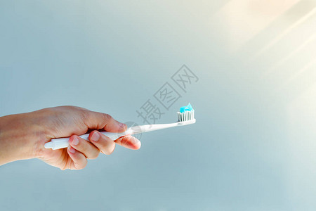 女手持牙刷和牙膏贴上牙膏用蓝牙图片