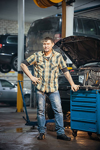 汽车修理服务严重鲁莽的机械师站在工具箱旁图片