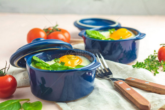 kokotcocotte法式早餐在蓝色陶瓷烘焙模具中的烤意大利风格的蔬图片