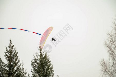滑翔伞在阿尔泰冬季山脉的天空中飞翔图片