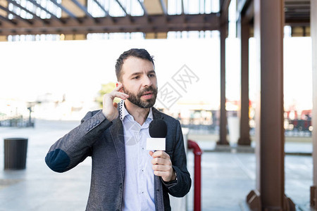 一名西班牙裔男新闻播报员在广播中用麦克风对着他图片