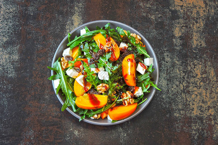 健康沙拉配柿子芝麻菜坚果和羊乳酪健身食品Superfoods维生素图片