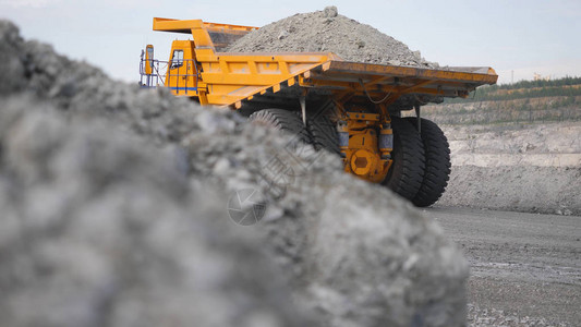 在路上的卡车驾驶生涯自卸车运载露天开采的矿石露天白色多级采石场背景下采矿业的背景图片