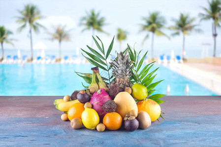 沙滩上的什锦热带水果橙子菠萝酸橙芒果火龙果橙子香蕉红毛丹和荔枝一组异国情背景图片