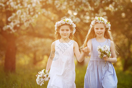 美丽的年轻女孩穿着长裙在花园里盛开的苹果树微笑的女孩拥抱玩乐和享受春图片