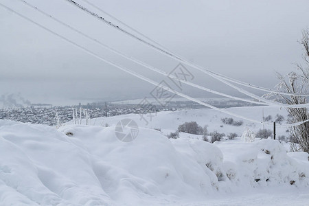 电线上冰冻的冰丝与城市冬图片