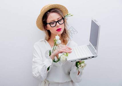 穿着白玫瑰袖子有笔记本的漂亮女人在找什么东西春季概念或图片