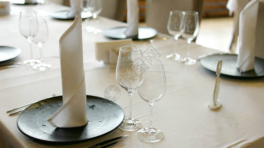 白葡萄酒杯餐盘餐巾纸和餐具都放在桌上图片