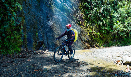 骑自行车的人在阳光明媚的玻利维亚死路上沿着巨大图片