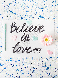相信在白色写下的爱情人节日带有鲜花和图片