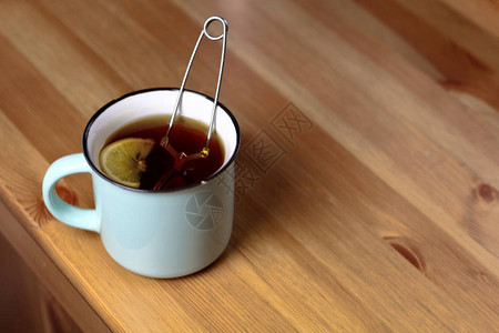 用柠檬加热茶和柠檬放在淡蓝色的杯子上一个煮茶图片