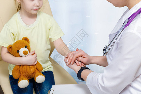 女儿科医生紧贴着一只小孩子的手图片
