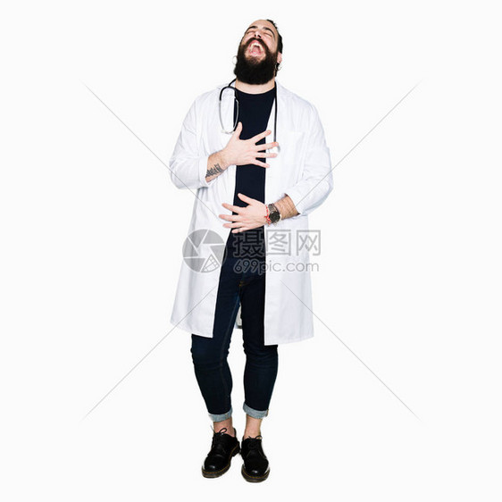 长头发的医生穿着医用外套和听诊器因为有趣的疯狂笑话而大声笑着图片