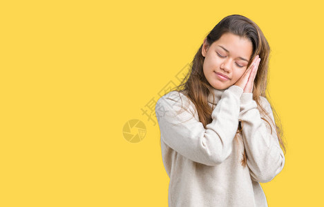 年轻美丽的黑发女人穿着高领毛衣在孤立的背景下睡觉累了做梦图片