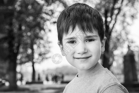 家庭与快乐的生活方式概念一个小男孩在模糊的城市风景背上的肖像图片