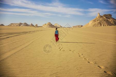走在沙漠中的年轻女人图片