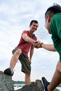 积极的亚洲青年徒步旅行者伸出双手图片