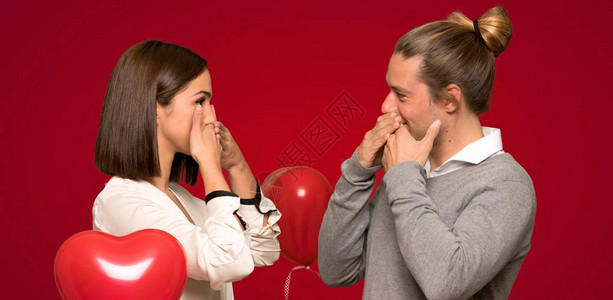 情人节的情侣亲手张嘴说些不合适的话来掩盖红色背景图片