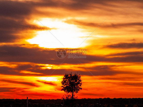 日落时的浪漫橙色天空在阴云多的一天在Dehes图片