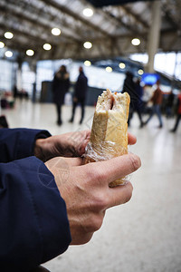 在火车站或电车站里吃三明治的天主图片