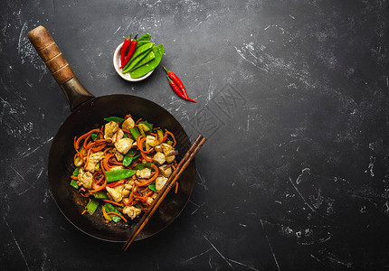 烤鸡炒和蔬菜用老生锈的烧锅黑石本底的筷子闭上顶端视图传统亚洲人泰人背景图片