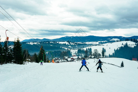 滑雪服和滑雪护目镜的滑雪者剪影在锚式滑雪缆车上慢上坡图片