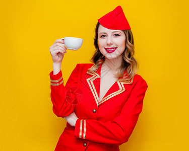 穿着红色制服的迷人老式空姐肖像和咖啡或茶图片