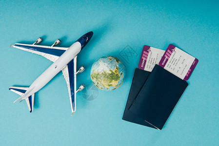 地球和飞机模型有蓝背景机票的护照背景图片