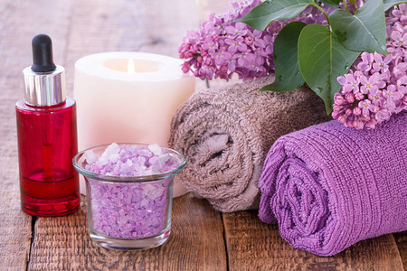 花粉红瓶加香油烧蜡烛海盐碗和木板上洗手间用的毛巾斯图片