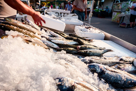 卖主的手直到安排鱼在跳蚤户外市场出售图片