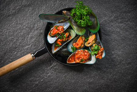 与壳牌鱼绿贝壳一起烹饪的全海产食品板背景图片