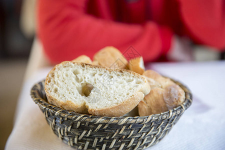 桌子上篮子里切面包的特写视图图片