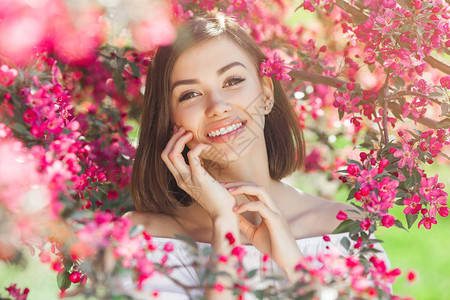 关闭了年轻美丽的女人与完美光滑的皮肤的肖像花丛中的美女美丽女图片