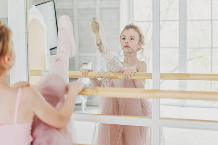 舞蹈课上的年轻古典芭蕾舞演员女孩美丽优雅的芭蕾舞女演员在白光大厅的大镜子附近穿着粉色短裙图片