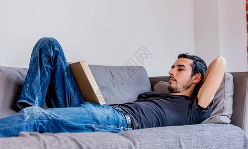 真正的男人躺在沙发上看一本书图片