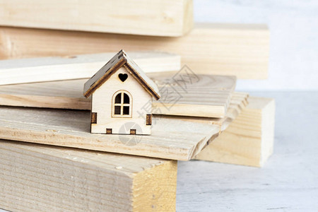木制背景上的房子模型建设和改造的概念图片