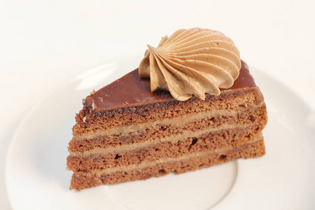 一块美味的巧克力寿终层蛋糕甜点配有巧克力奶油装饰品图片