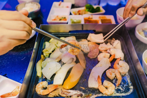 享受在韩国餐厅与家人一起吃韩式BBQ传统著名食图片